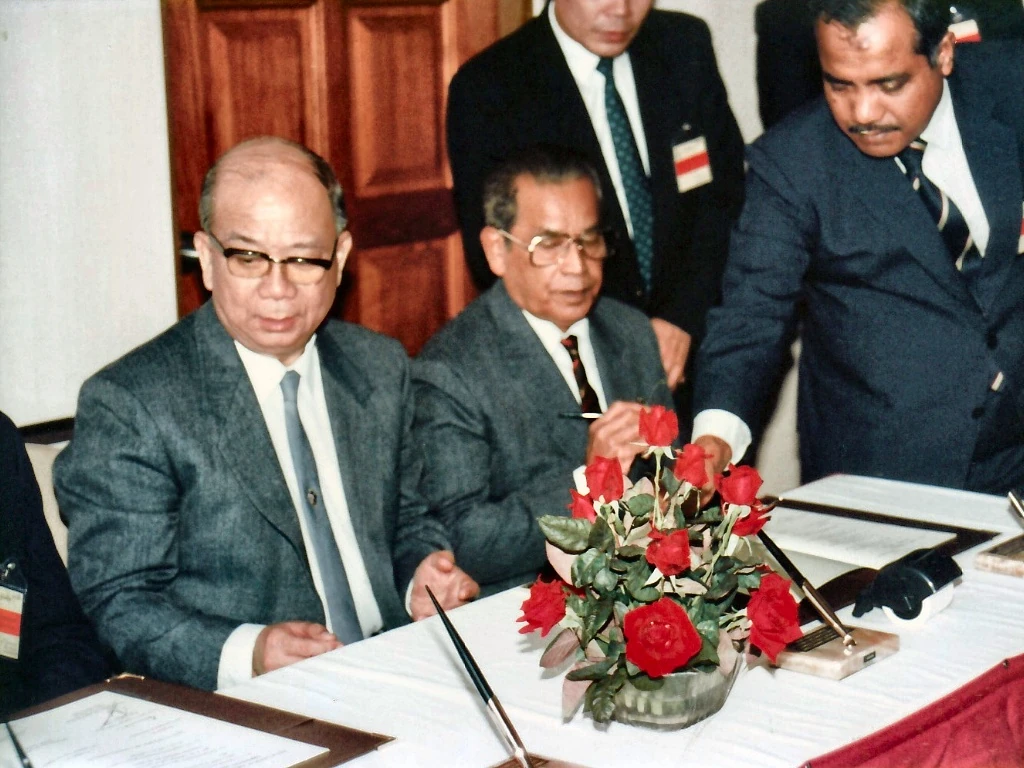 1989年12月2日合艾签署大典上，马共中央委员拉昔·迈丁（中）签署《行政安排备忘录》，左为陈平总书记