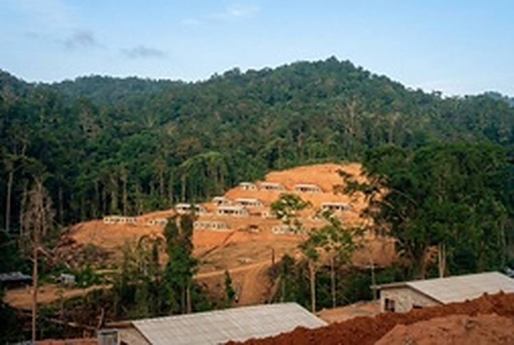 山谷盆地中的和平村建设全景：推土机开辟出的层层梯田状宅基地上，新房拔地而起。