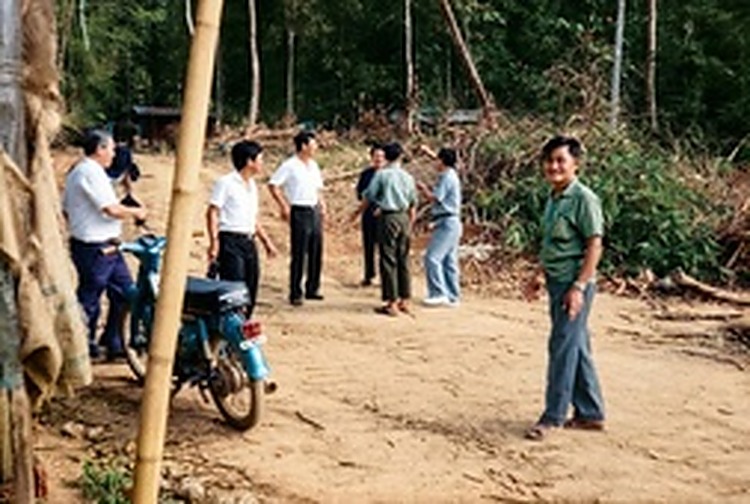 和平村村民与干部聚集在新建成的村道旁，迎候泰国军方访问团的到来。