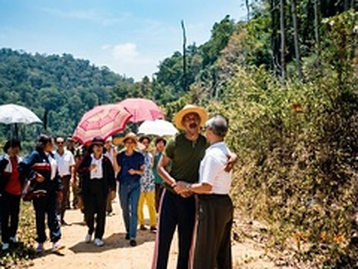和平村妇女与村民撑伞列队在山坡道旁，热情欢迎泰国军政代表团上山视察。