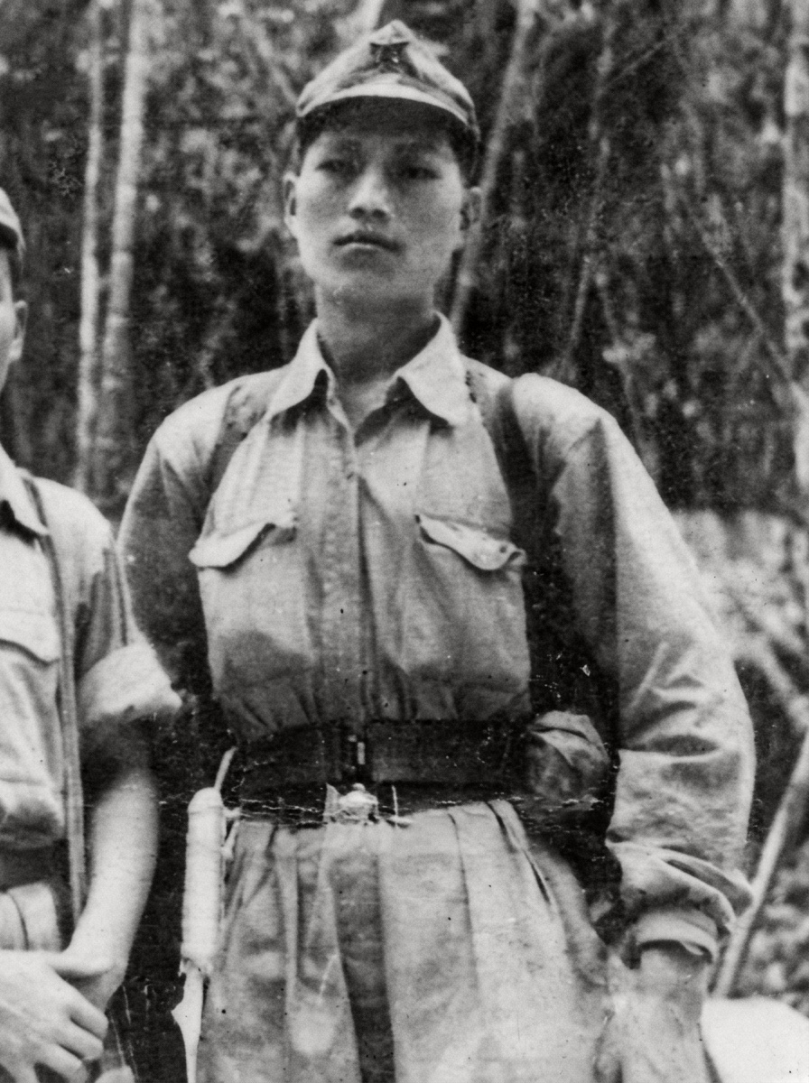 1953年12月抗英民族解放战争期间，身着卡其布军装、头戴五角星军帽并腰佩手枪套的马来亚民族解放军战士坤雀肖像（背面墨书“坤雀 于一九五三年十二月”）。