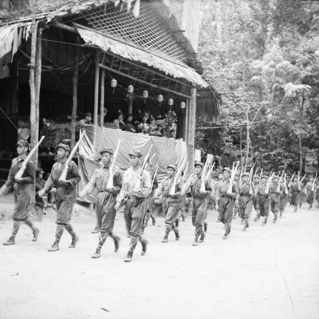 1964年马来亚民族解放军步兵分队肩托步枪、迈着整齐步伐列队通过密林营地检阅台。