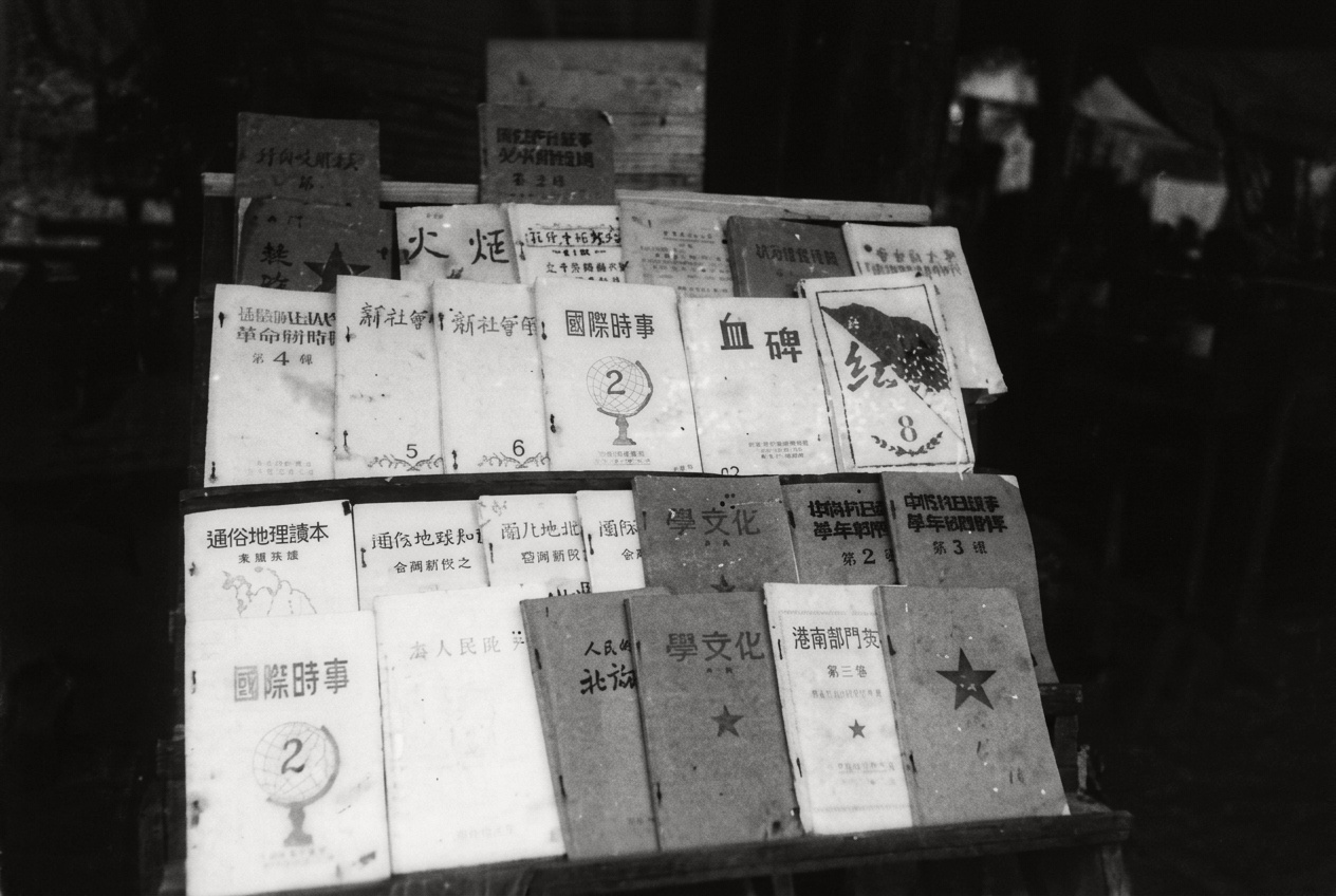 1967年密林营地图书架上陈列的《火炬》、《红星》、《血碑》、《国际时事》、《通俗地理课本》与《学文化》等部队油印书刊。
