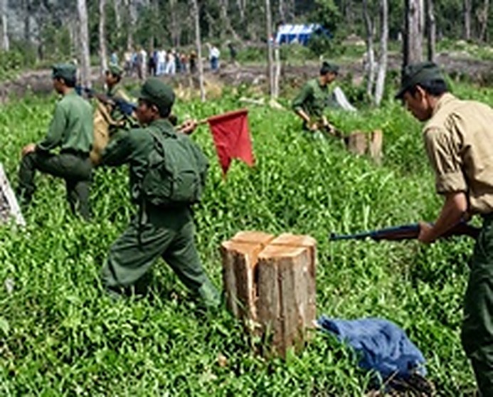 庄严的自行销毁仪式：在红旗指引下，人民军战士手握枪管，在粗大的原木墩上亲手砸断步枪木托，履行“自行销毁武器而非缴械投降”的铁律。
